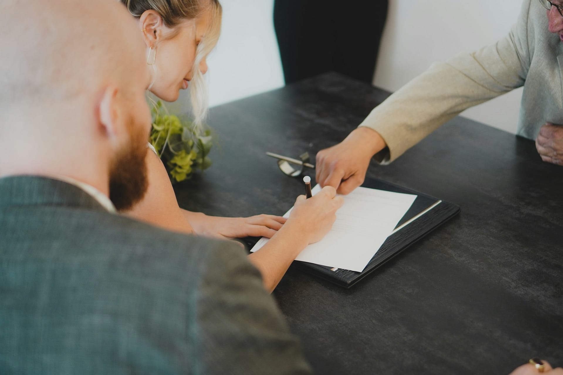 Two people signing a document at a table